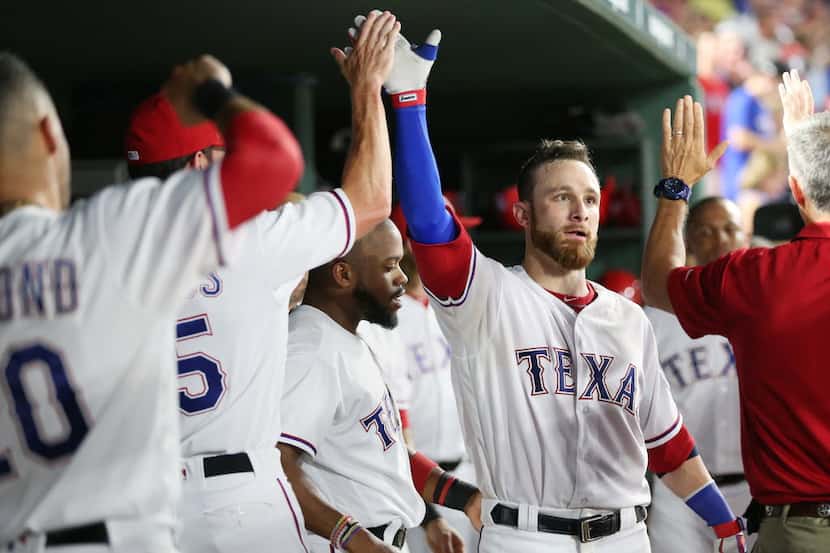 Texas Rangers catcher Jonathan Lucroy (25) celebrates with teammates after hitting a solo...