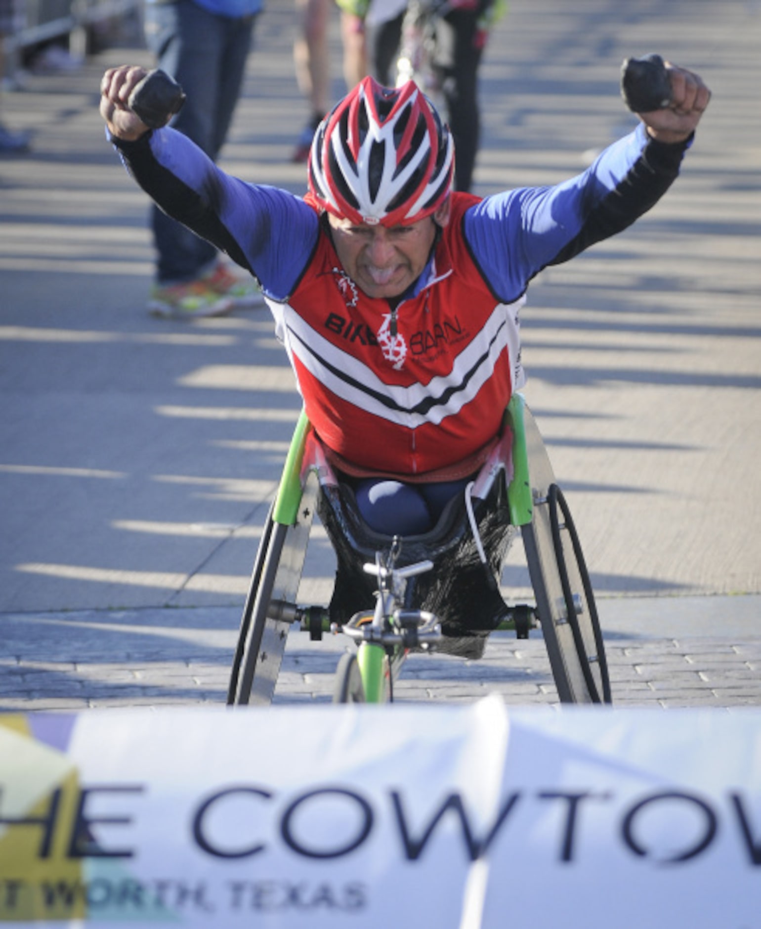 Ramiro Bermudez of Houston, crosses the finish line to place first among wheelchair...