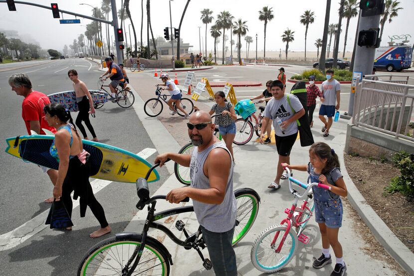 Personas esperan a cruzar la Autopista de la Costa del Pacífico el domingo 26 de abril de...