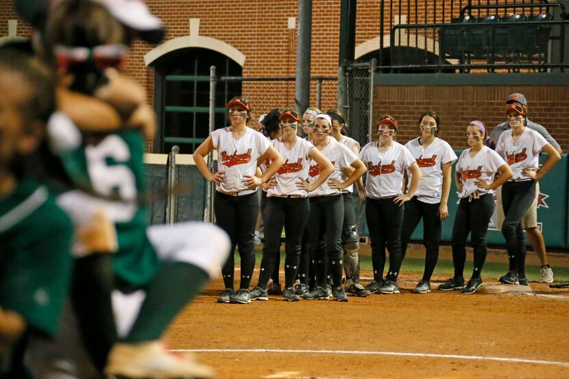 The Rockwall Lady Jackets watch as the Woodlands celebrate their walk-off 2-1 win during the...
