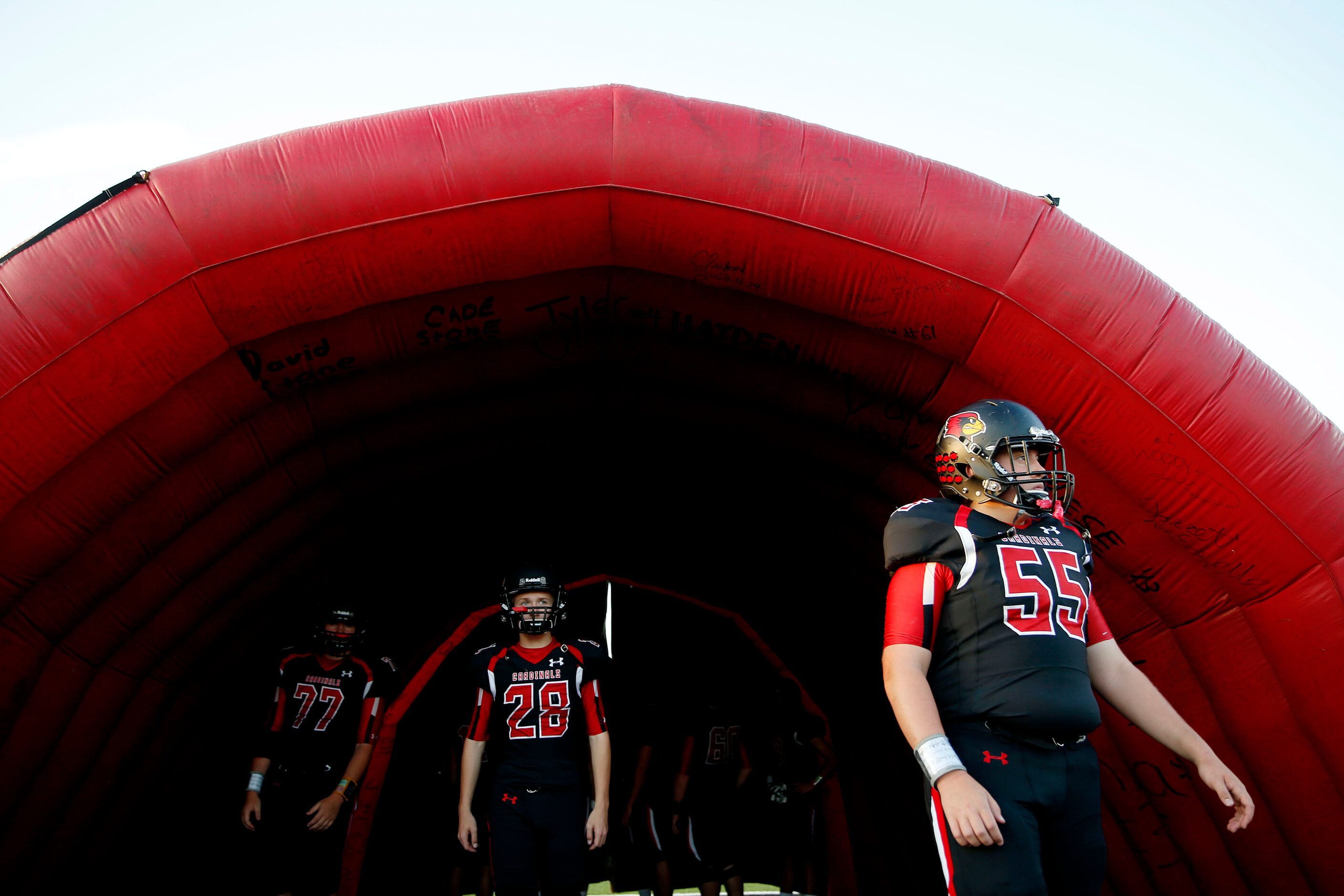 Fort Worth Christian player Jake Gressett (right) and teammates wait to run through the...