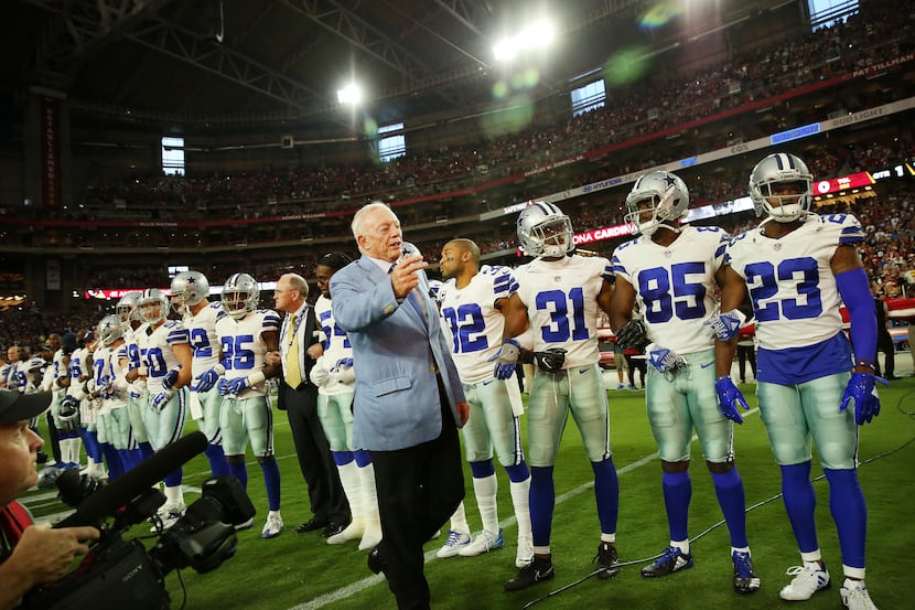Dallas Cowboys owner Jerry Jones ushered photographers back to their position as stadium...