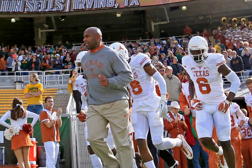 Texas head coach Charlie Strong, left, takes the field with his players against Baylor at...