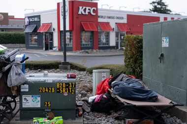 An unhoused person sleeps in Brookings, Ore. The Supreme Court on Friday allowed cities to...