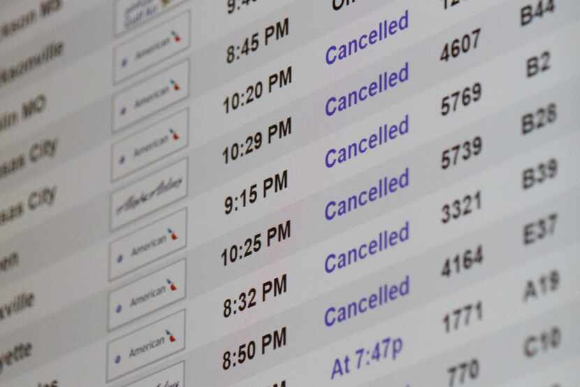 Flight cancellations for American Airlines dotted the board at DFW International Airport...