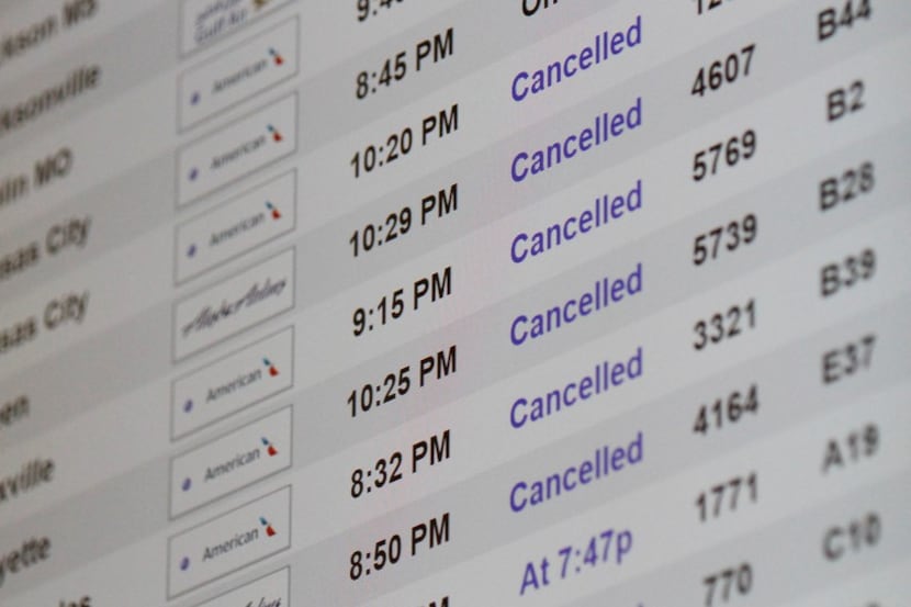 Flight cancellations for American Airlines dotted the board at DFW International Airport...
