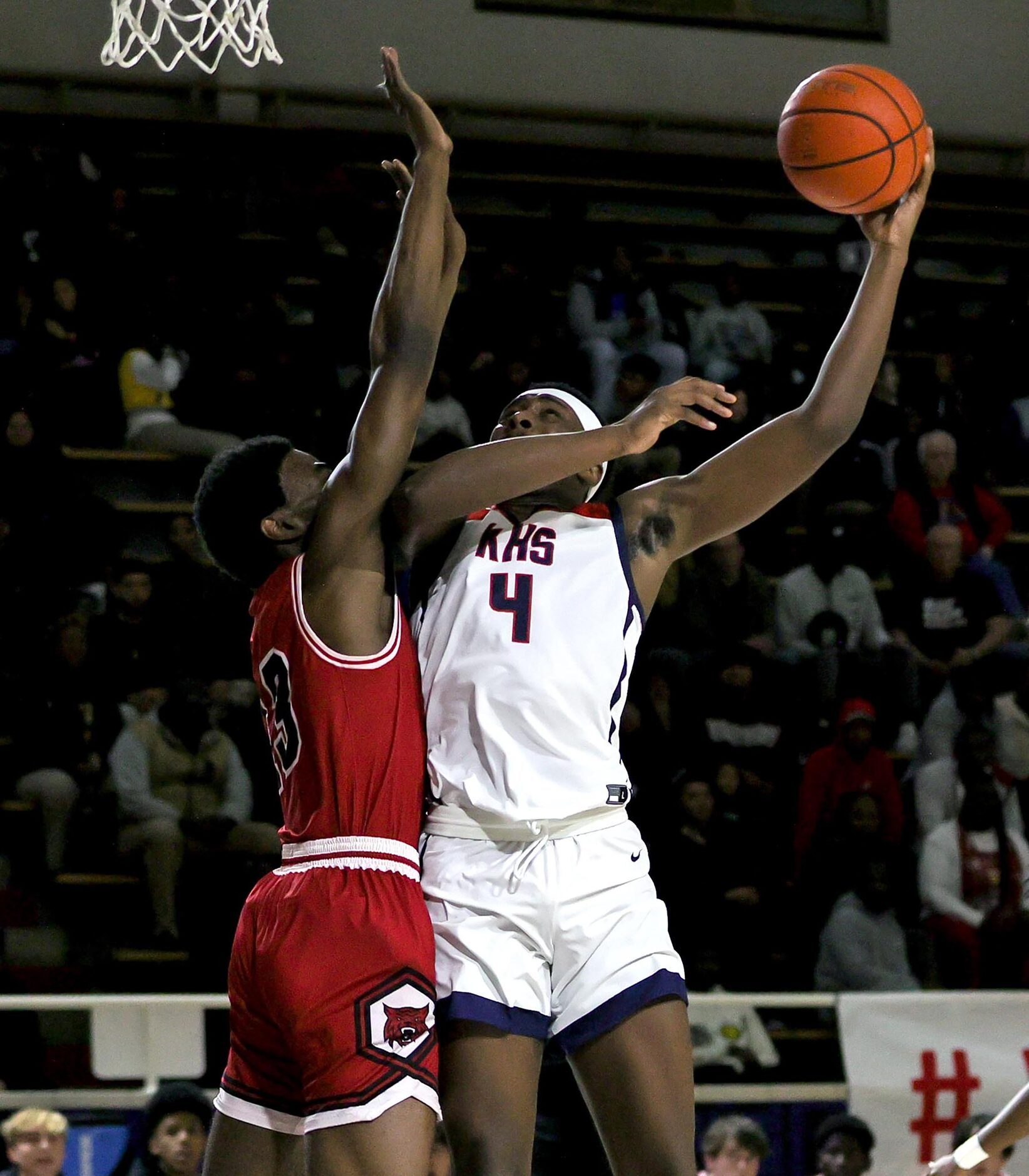 Kimball forward DaCannon Wickware (4) tries to get off a shot over Woodrow Wilson forward...