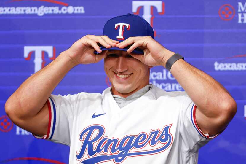 Texas Rangers top pick Wyatt Langford smiles as he wears the cap during a press conference...