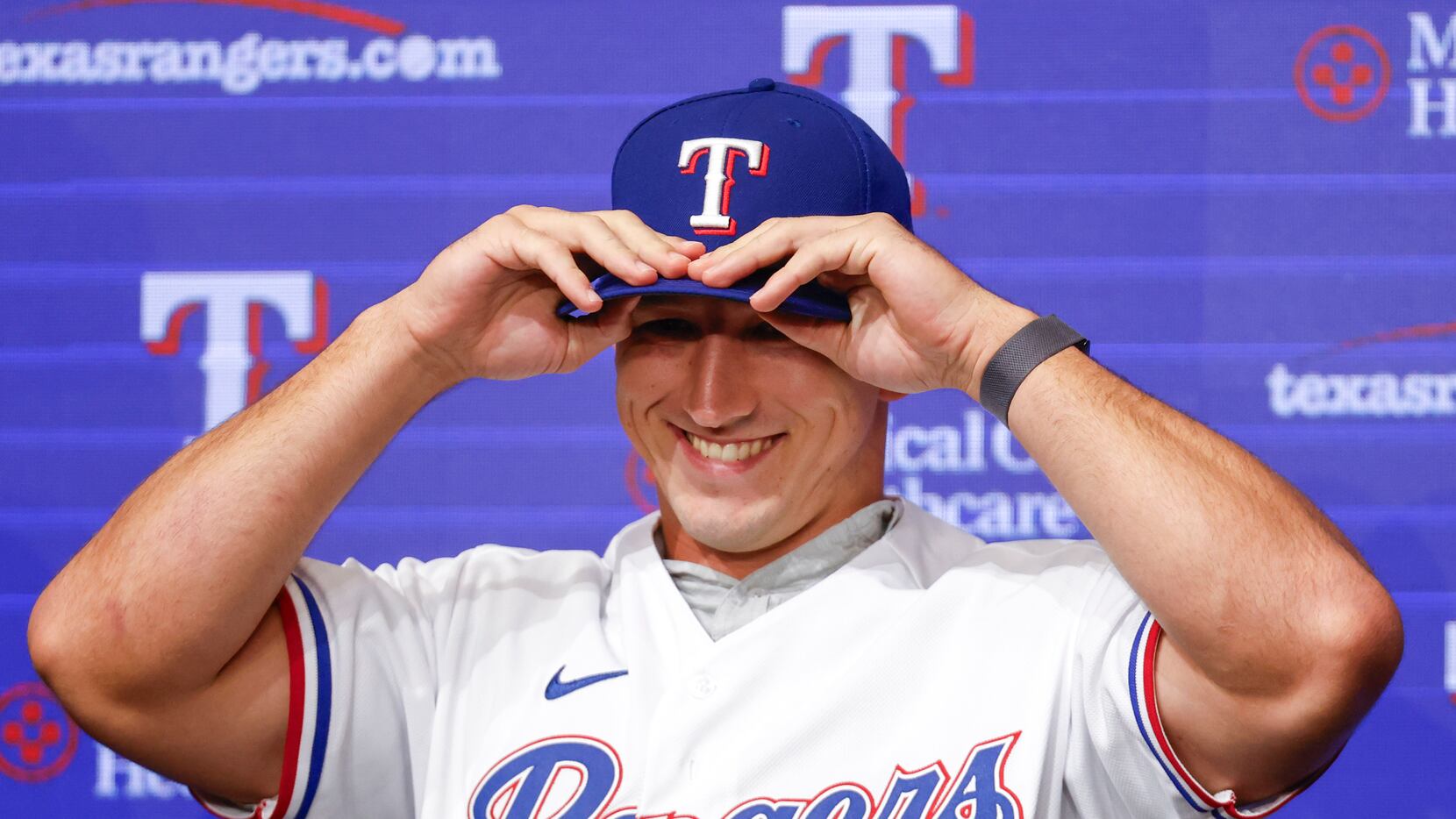 Texas Rangers top pick Wyatt Langford smiles as he wears the cap during a press conference...