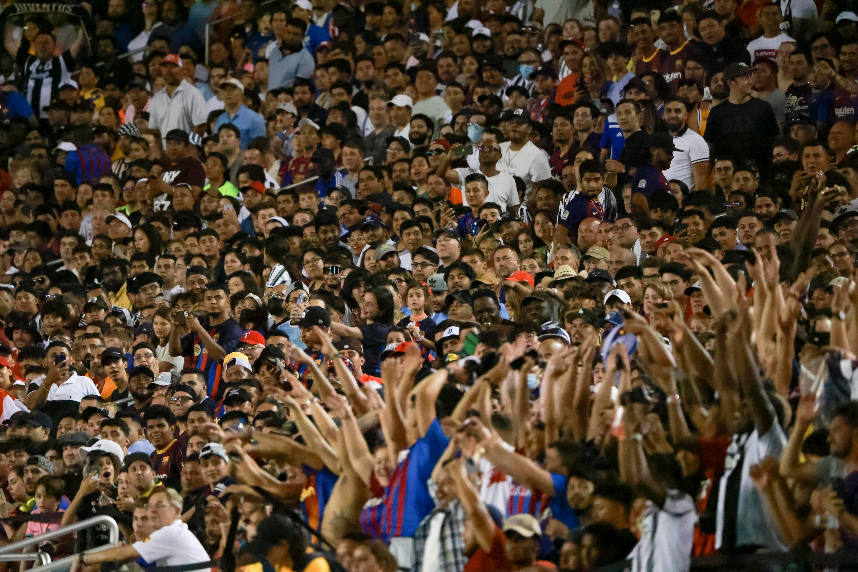 Crowd members watch as the wave of fans cheering gets closer to them, Tuesday, July 26, 2022...