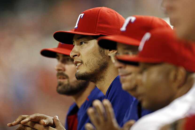 Texas Rangers starting pitcher Yu Darvish looks on from the dugout during the fourth inning...