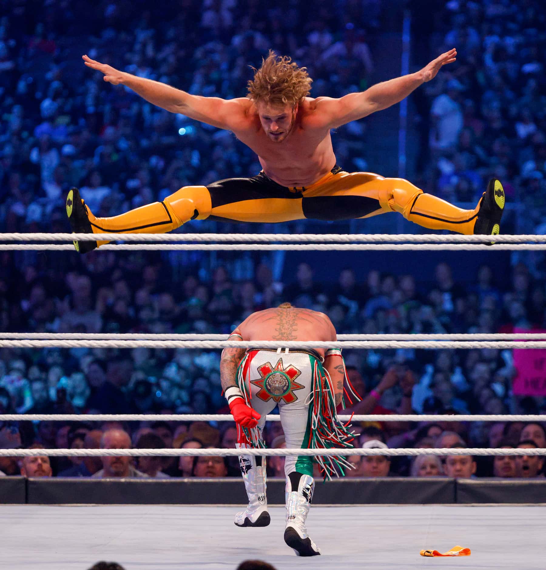 Logan Paul does the splits as he leaps over Rey Mysterio during WrestleMania 38 at AT&T...