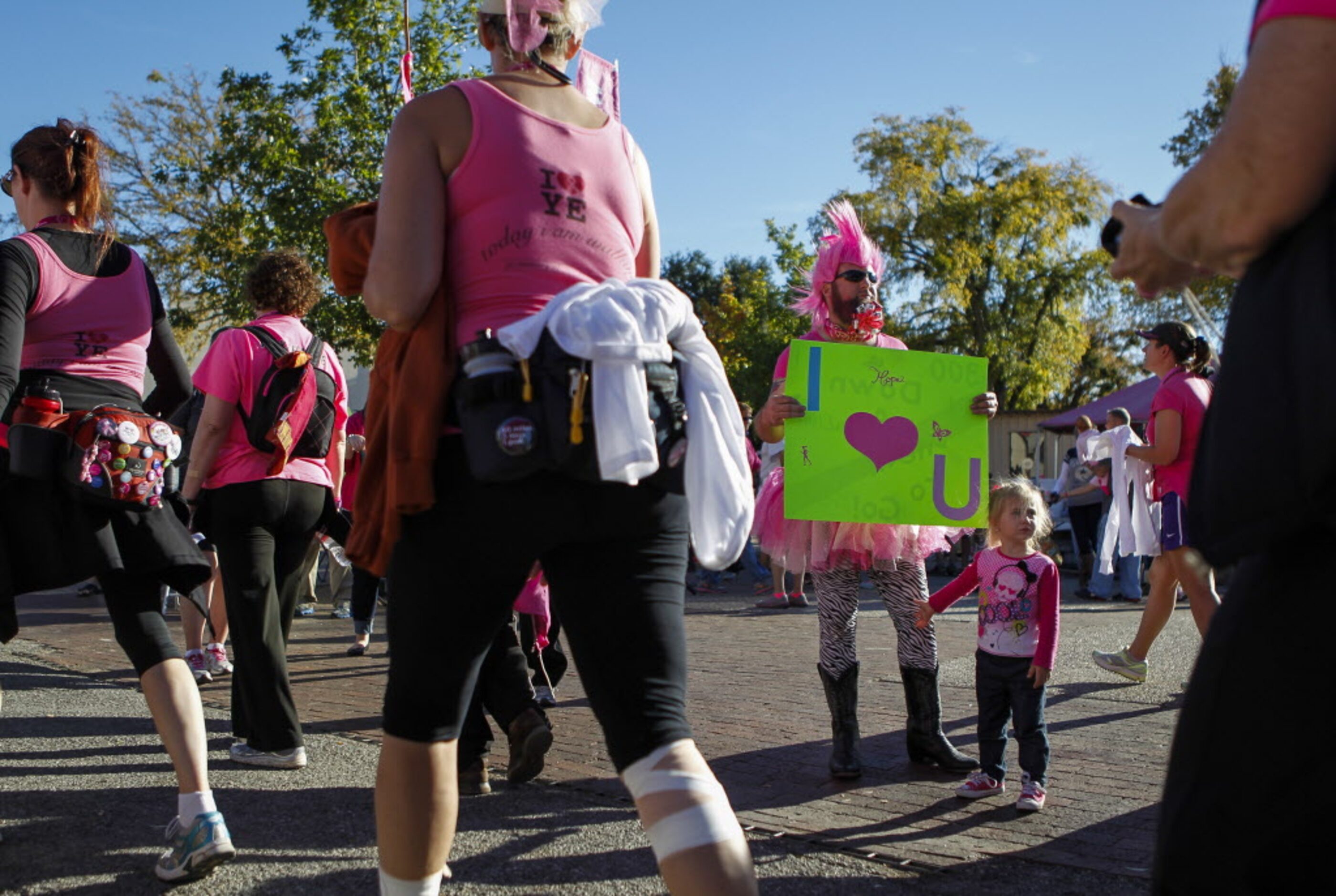 Wayne Richardson of Kennedale, Texas and his three-year-old daughter, Gracee, greet walkers...