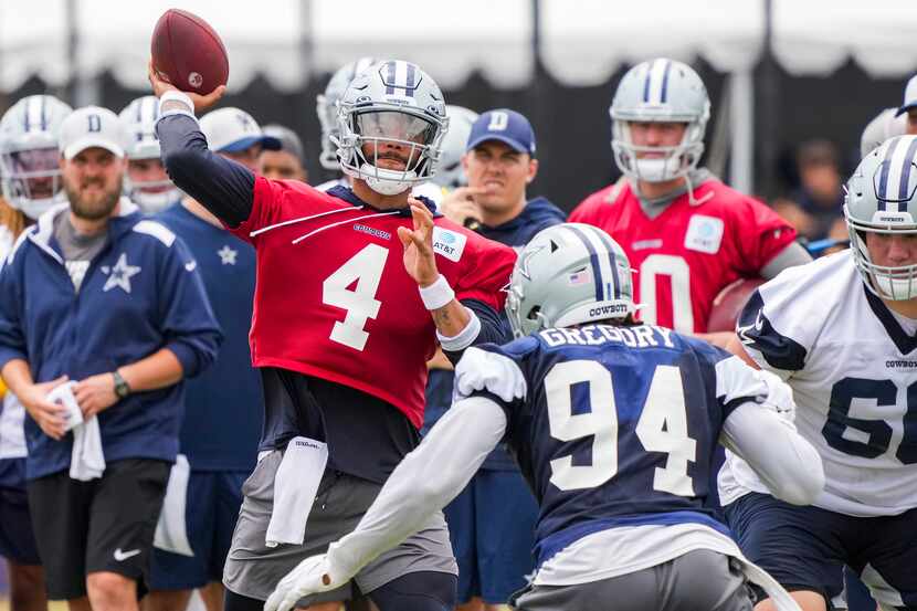 El mariscal de campo de los Cowboys de Dallas, Dak Prescott (4), lanza un pase bajo presión...