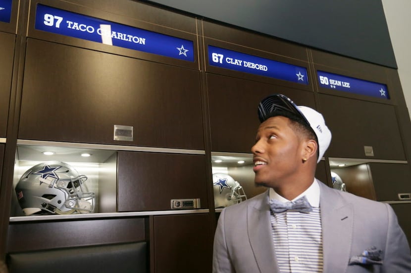 The Dallas Cowboys' No. 1 draft pick, defensive end Taco Charlton, looks at his new locker...