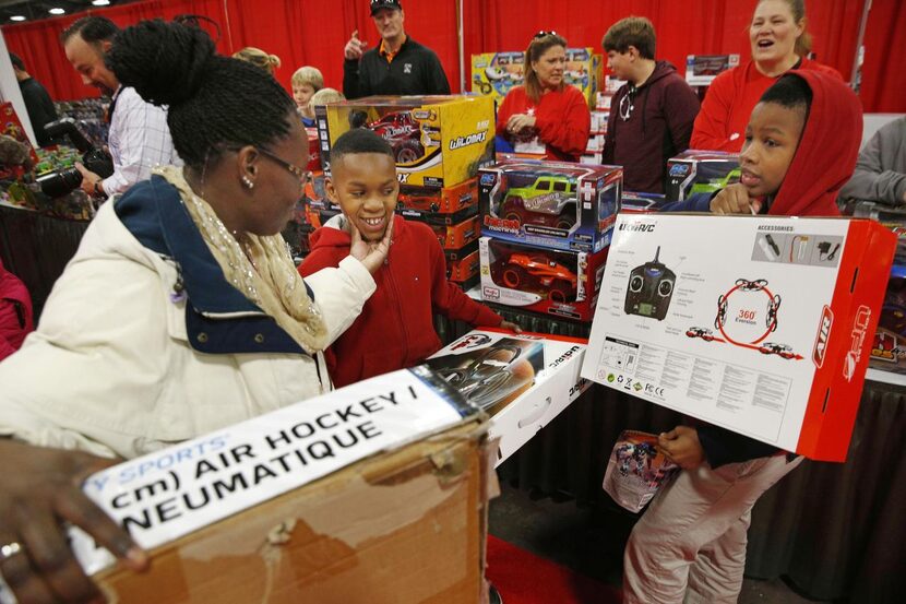 Dematris Johnson squeezes  the cheeks of her son Jaydon Johnson, 9, who picked out toys...