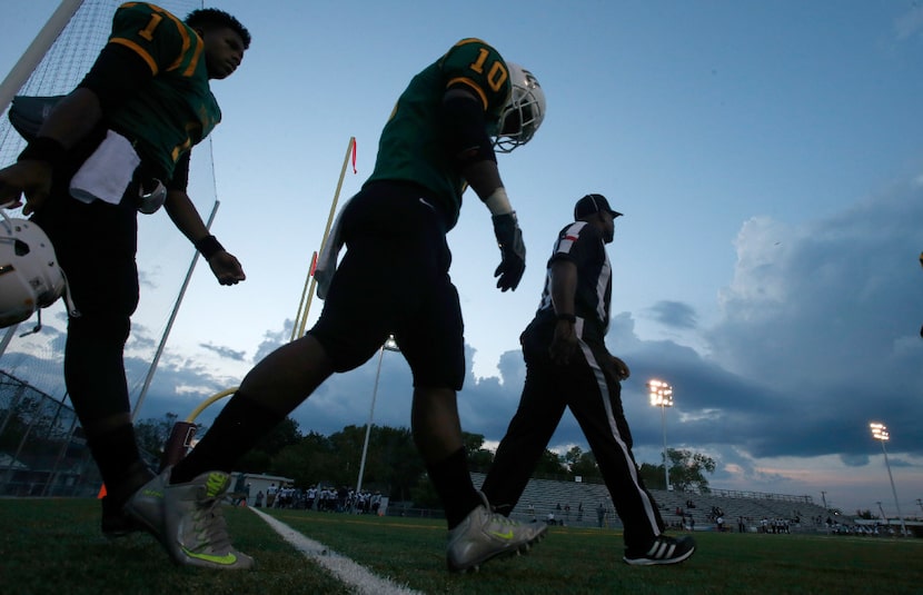 Madison linebacker Kevin Walder (1) and quarterback Travoin Jackson (1) make their way with...