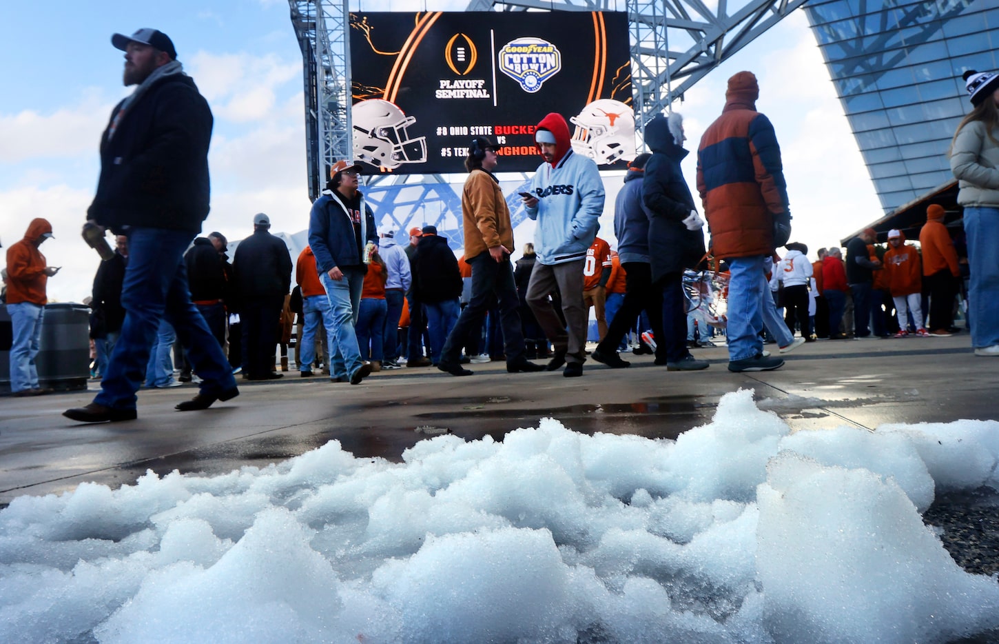 With melting snow on the east plaza, Texas Longhorns and Ohio State Buckeyes fans arrive for...