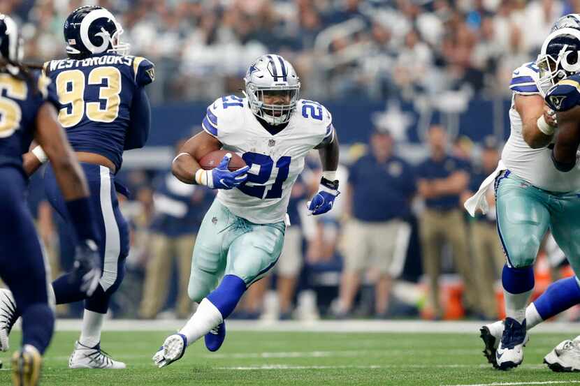 Dallas Cowboys running back Ezekiel Elliott (21) finds a hole in Los Angeles Rams defense as...