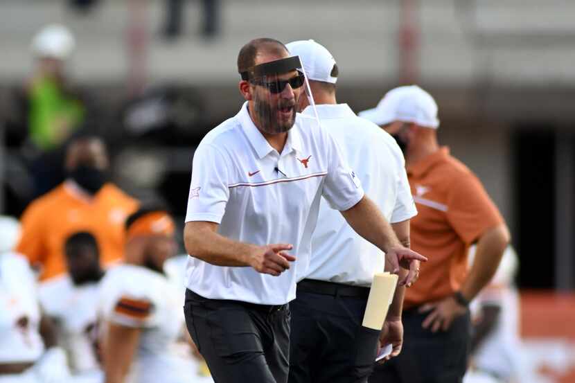 Texas offensive coordinator Mike Yurcich yells instructions during warmups before a game...