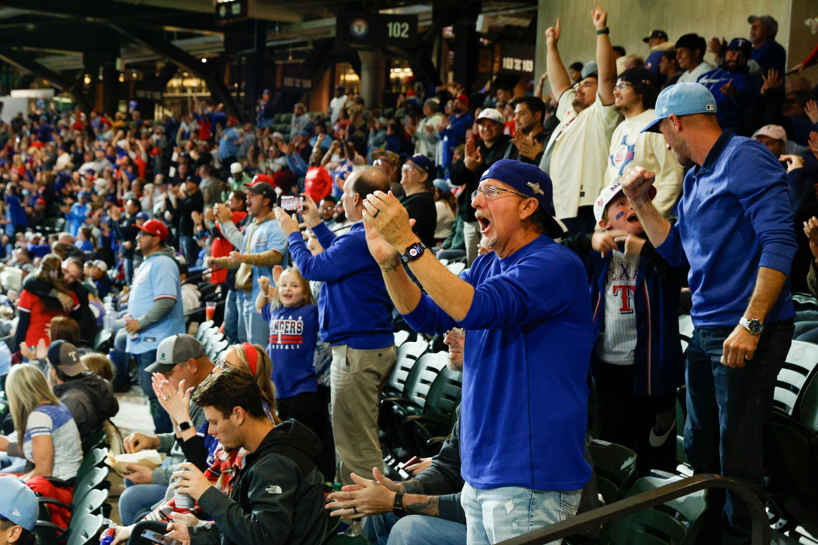 Texas Rangers fans cheer after shortstop Corey Seager hit a homer during the third inning in...