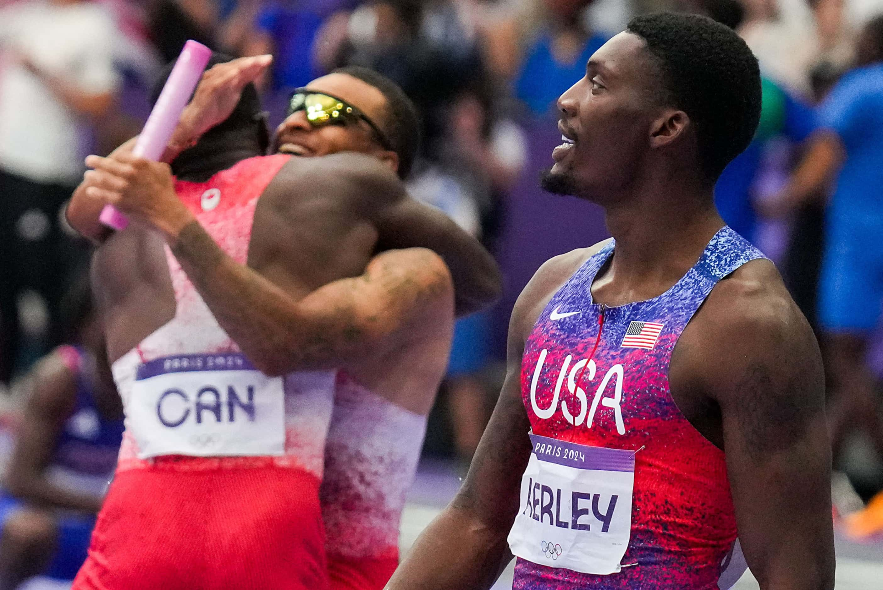 Fred Kerley of the United States walks off the track as Aaron Brown (facing) and Andre De...