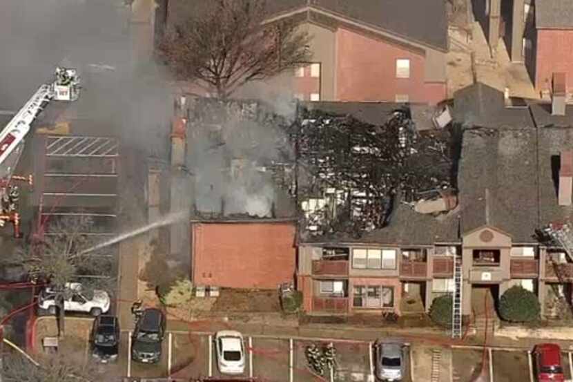 Firefighters battle a fire at a Lewisville apartment complex Tuesday morning. Smoke was...
