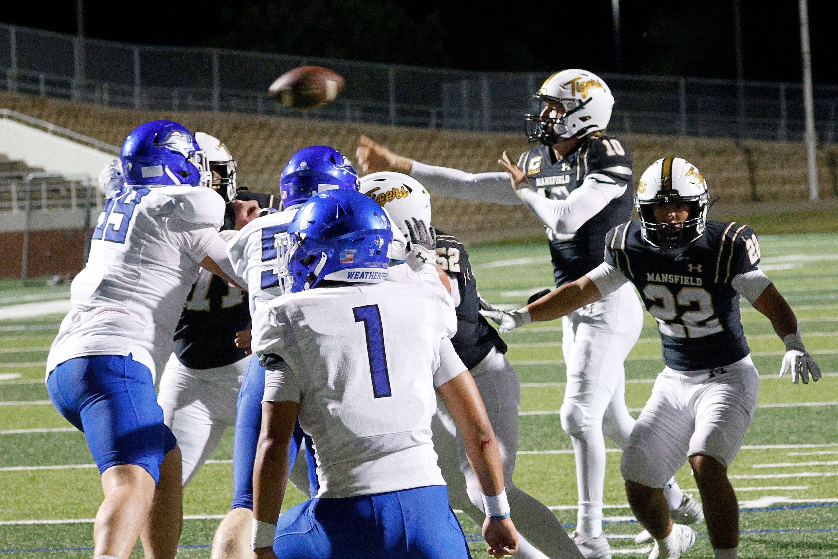 Mansfield's quarterback Braxton Van Cleave (10) passes under pressure from Weatherford...