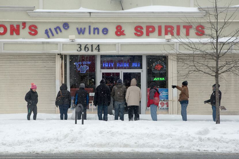  People wait for a liquor store to open along Georgia Ave. in the Parkview neighborhood on...