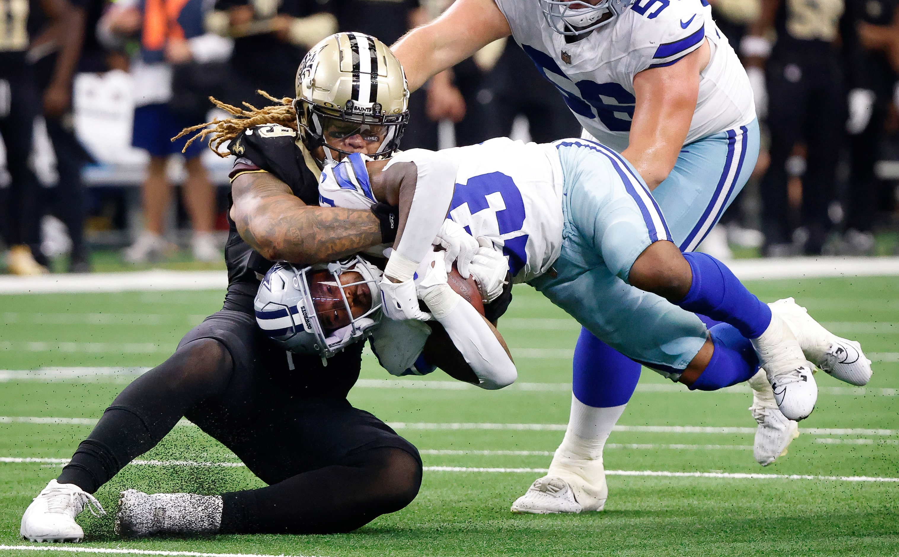 New Orleans Saints defensive end Chase Young (99) wrestles Dallas Cowboys running back Rico...