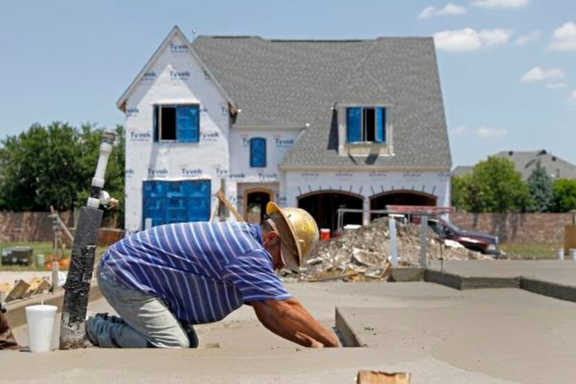 
A construction worker applied the final touches to a foundation in Plano, where Toyota will...