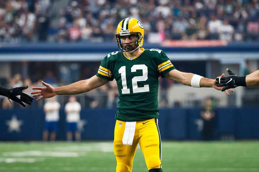 Green Bay Packers quarterback Aaron Rodgers celebrates with teammates after a 7-yard...