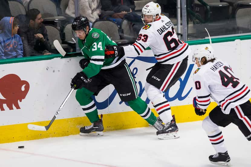 Dallas Stars right wing Denis Gurianov (34) keeps control of the puck ahead of Chicago...