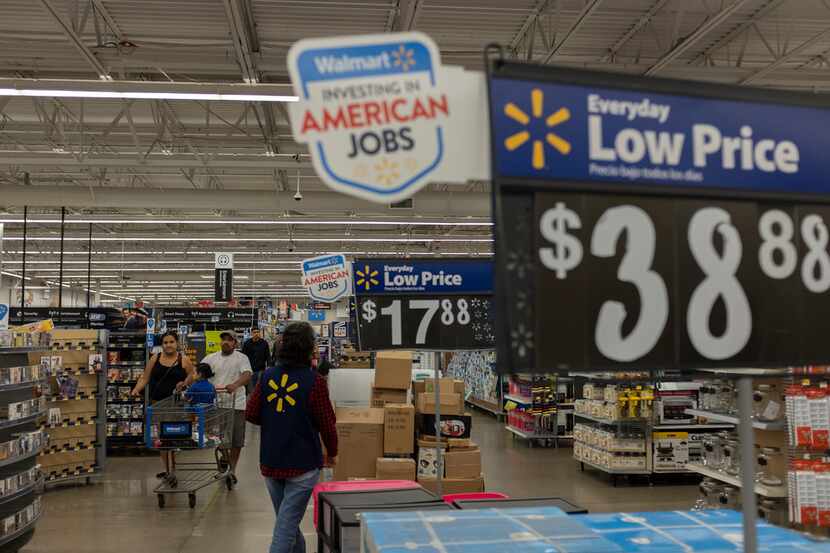 Customers and Walmart staff walk past merchandise at a Walmart store on June 14, 2018 in San...