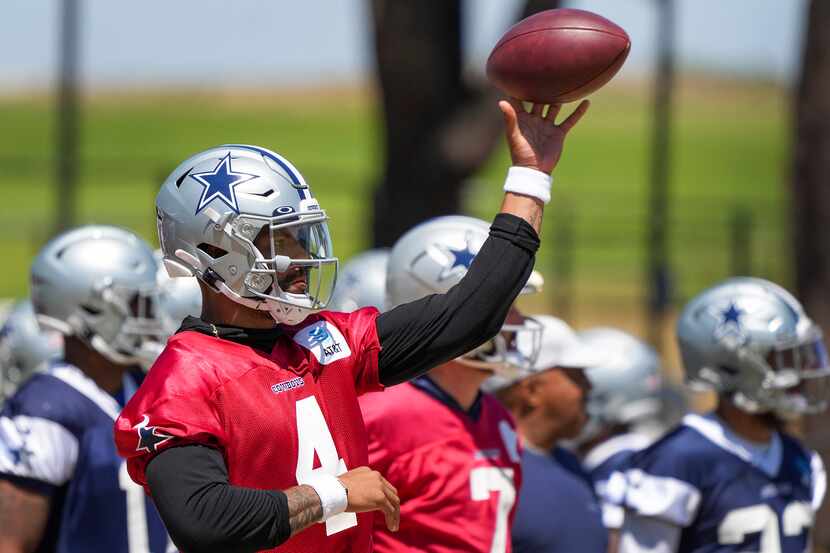 Dallas Cowboys quarterback Dak Prescott tosses a ball with his left, no-throwing, arm during...