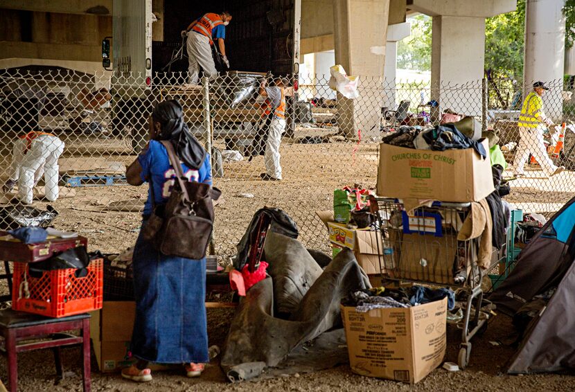 Eva James watches as crews clean up a homeless encampment Tuesday, October 25, 2016 in East...