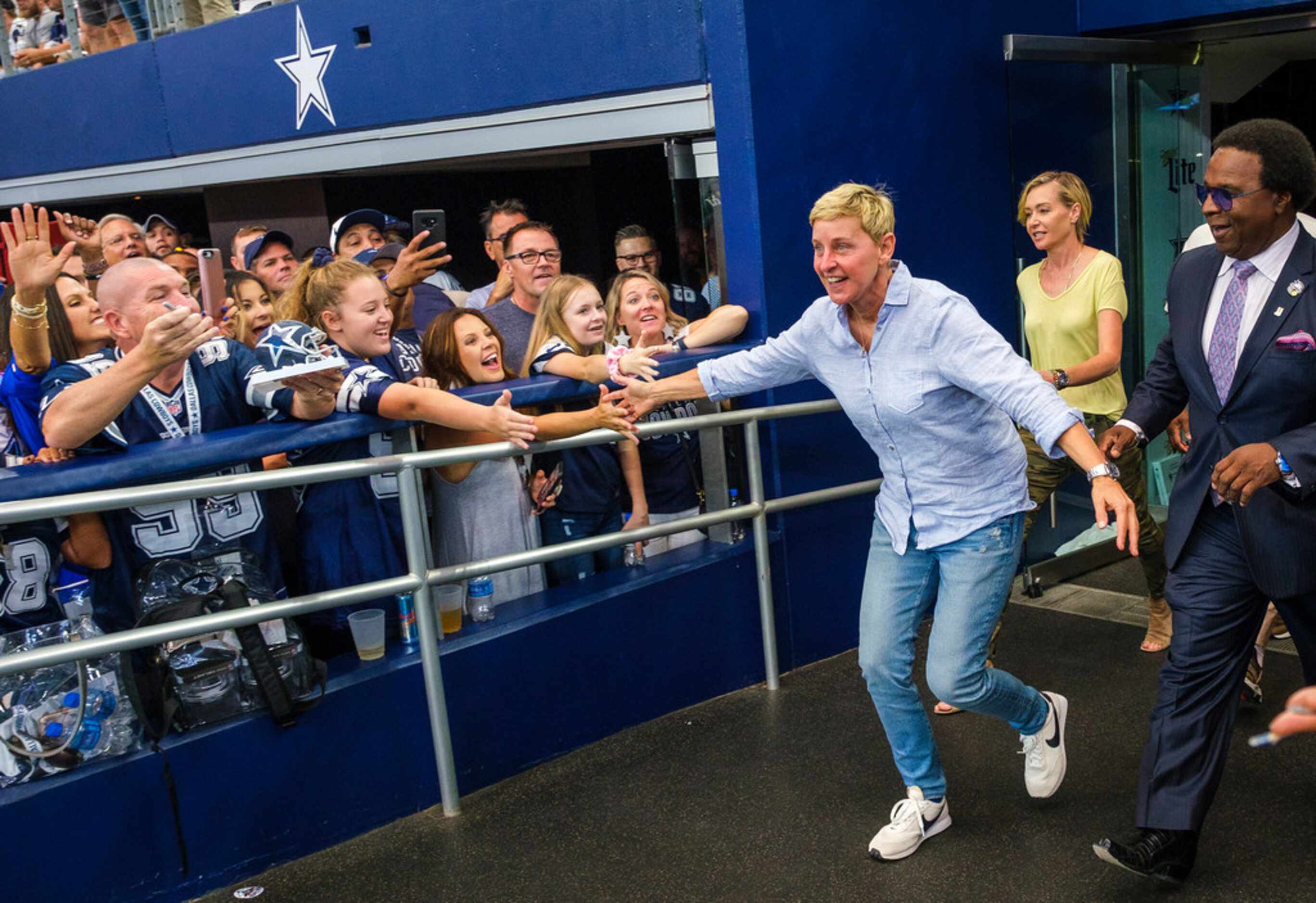 Ellen DeGeneres high fives fans before an NFL football game between the Dallas Cowboys and...
