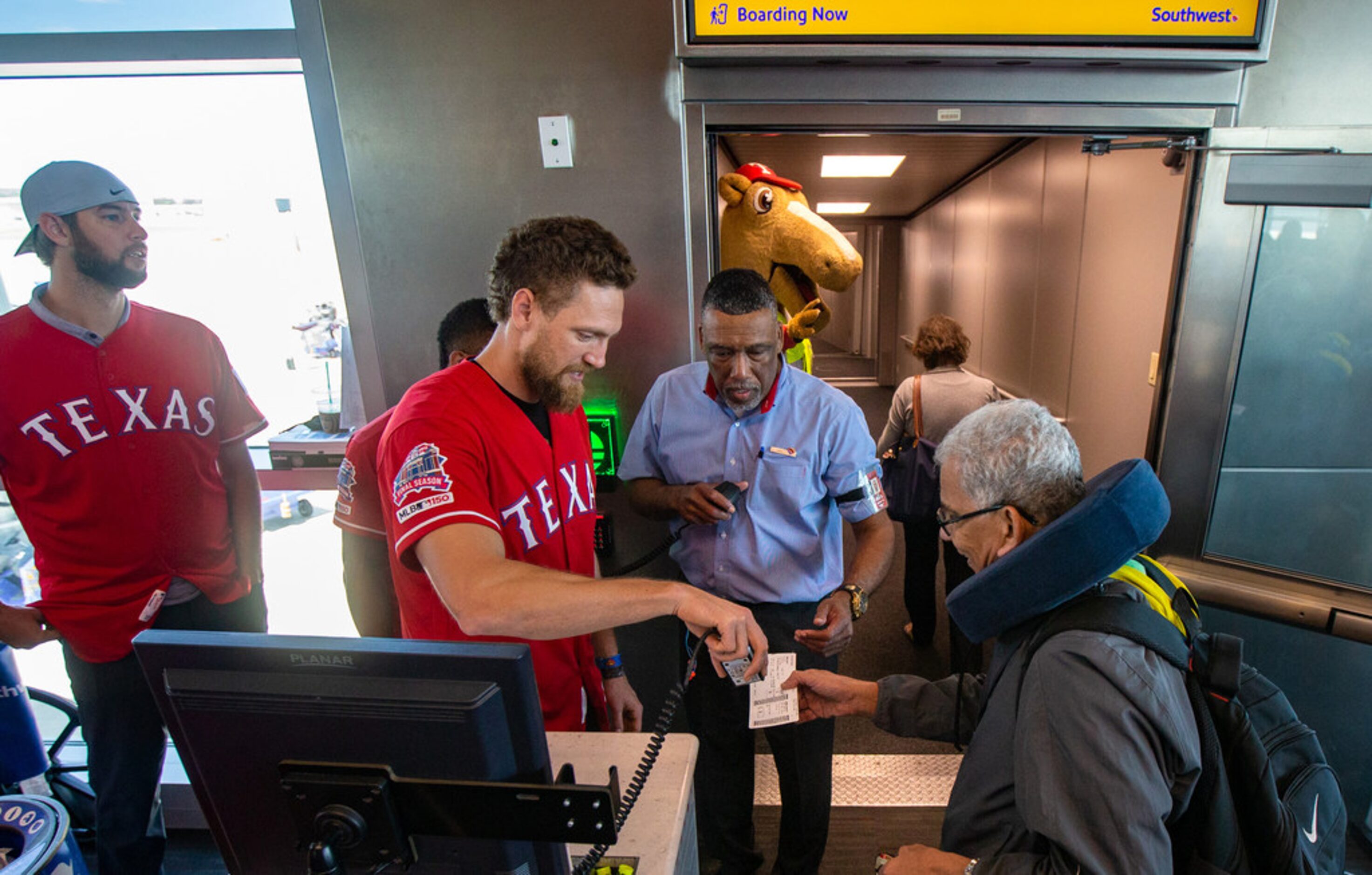 Texas Rangers right fielder Hunter Pence (center) scans boarding passes with the help of...