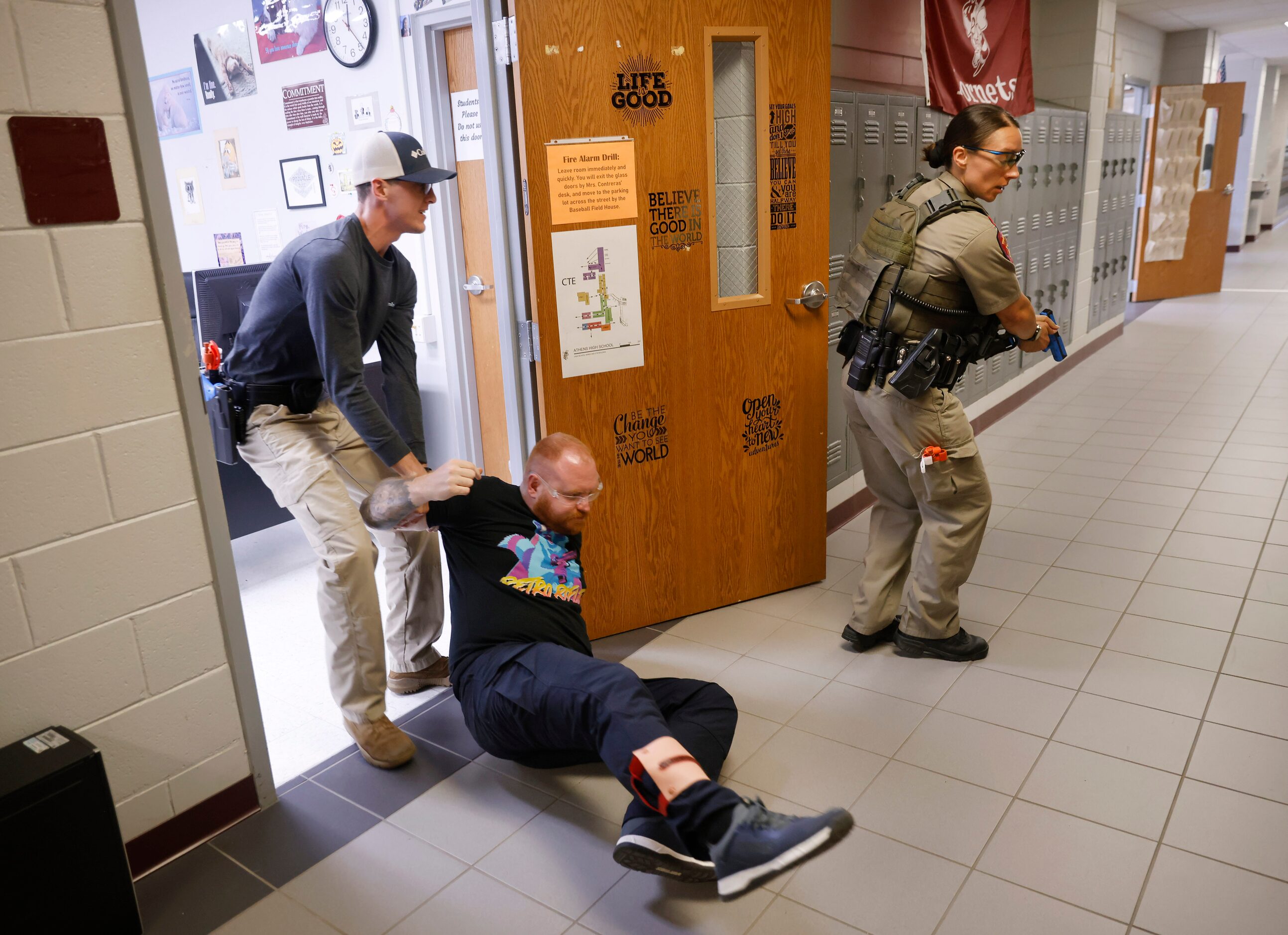 Henderson County Sheriff’s Deputy Cody Baker (left) drags a victim portrayed by Athens...