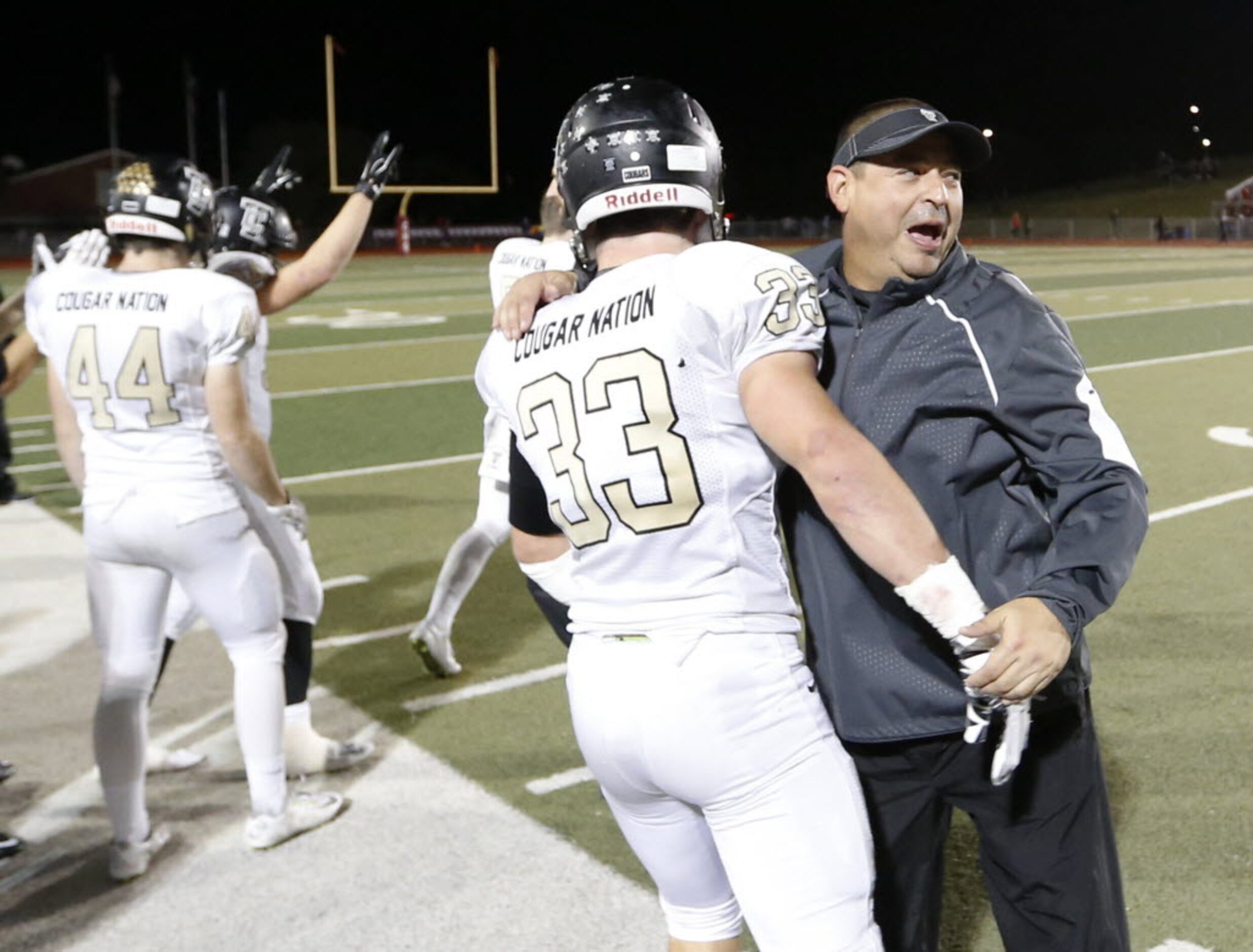 The Colony's head football coach Rudy Rangel celebrates with Jake Hood after defeating...