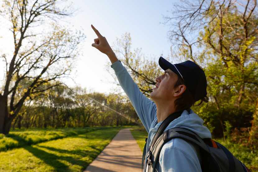 Birdwatcher Kalder Korte, points up on the trees to identify a certain species of a bird at...