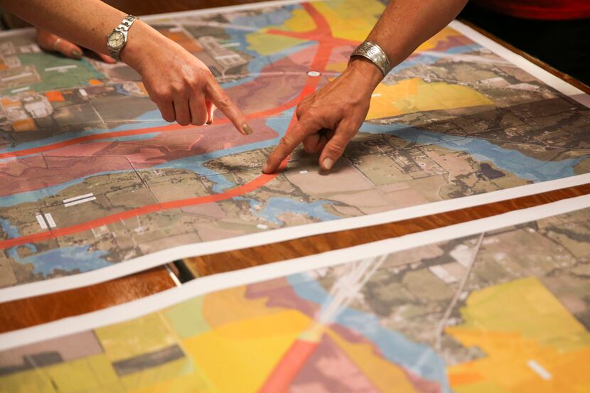Community members discuss an alignment map during a Texas Department of Transportation open...