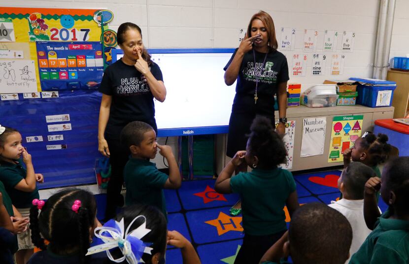 Principal Onjaleke Brown (right) participates in a song with Pre-K teacher Librada Gil and...