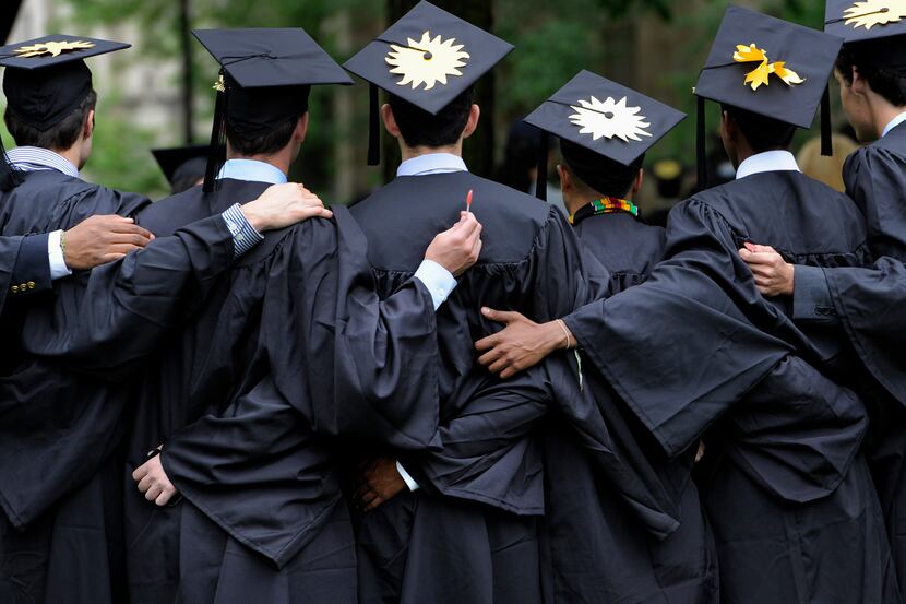 FILE - In this May 20, 2013 file photo, graduates pose for photographs during commencement...