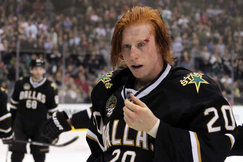 Dallas' Cody Eakin (20) is bloodied as he leaves the ice after a fight with Calgary's Jarome...