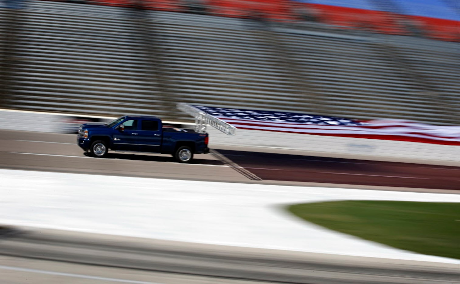 A 2017 Chevrolet Silverado HD hauls an American flag around the track at Texas Motor...