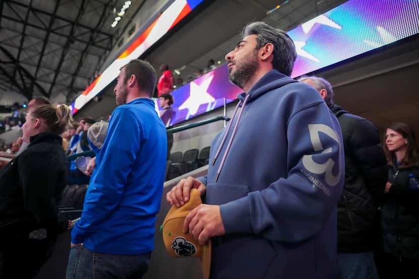 Parsa Bastami stands for the national anthem near the seats of his late friend Cody Ward...