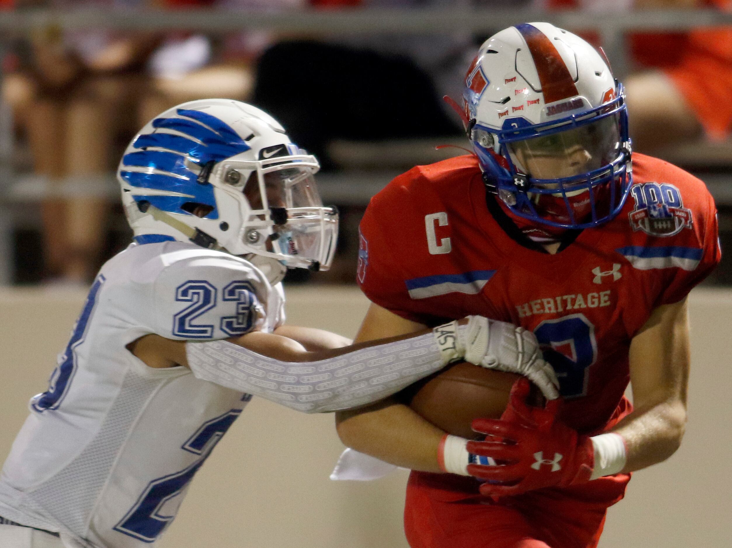 Midlothian Heritage running back Cullen Stone (2) works to protect the ball as he is tackled...