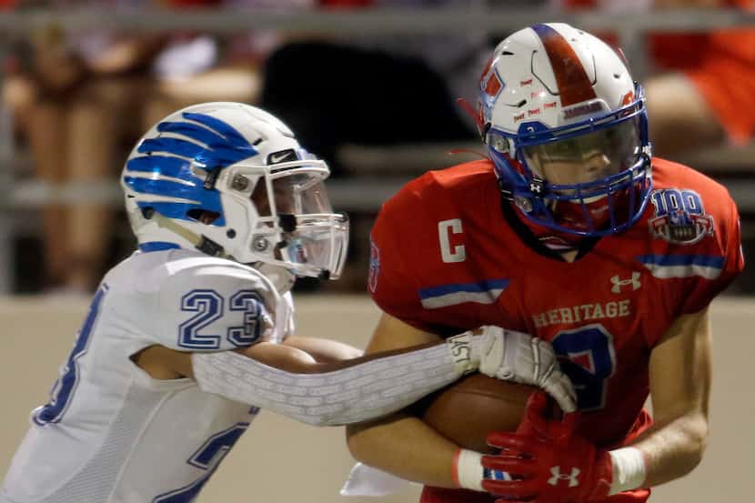 Midlothian Heritage running back Cullen Stone (2) works to protect the ball as he is tackled...