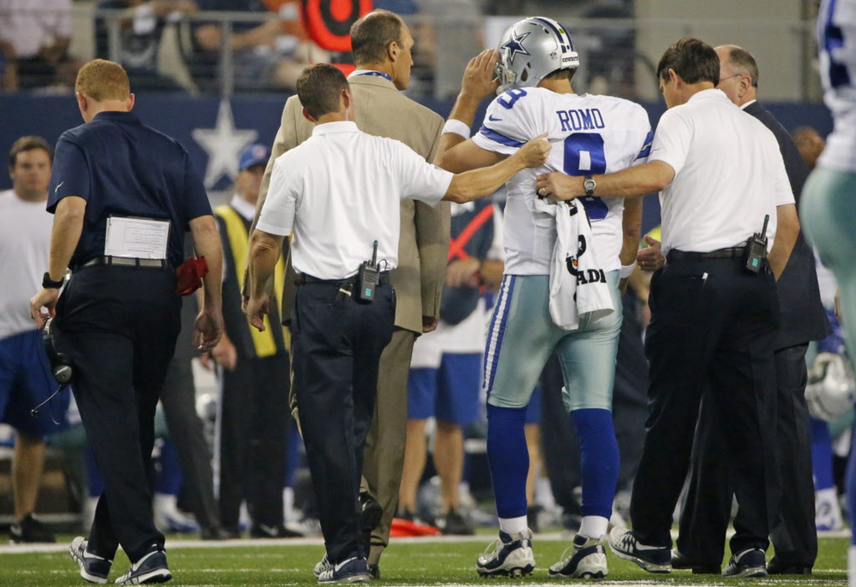 Dallas Cowboys quarterback Tony Romo (9) is helped off the field by trainers after being...